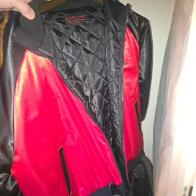 Sale Photo Thumbnail #66: C.R. England Global Transportation red and black satin jacket featuring a quilted inner lining and full zipper closure.