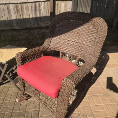 Sale Photo Thumbnail #99: Brown all-weather woven resin wicker patio rocking chair featuring a high back and a red seat cushion.