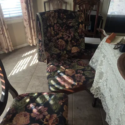 Sale Photo Thumbnail #84: Set of dining chairs upholstered in a dark floral tapestry fabric, accompanied by traditional wooden dining chairs in the background.