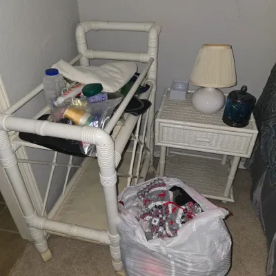 Sale Photo Thumbnail #15: White faux-bamboo rolling utility cart alongside a matching nightstand topped with a small lamp and decorative glass jar.