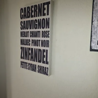 Sale Photo Thumbnail #96: Canvas wall art with a bus-sign style listing of various wine varietals in bold black typography.