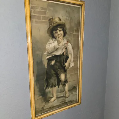 Sale Photo Thumbnail #3: Vintage framed art print depicting a barefoot newsboy wearing a straw hat and tattered clothes, housed in a thin wooden frame.