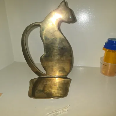 Sale Photo Thumbnail #111: Vintage brass cat figurine, featuring a stylized seated silhouette design with a subtle dish-style base.