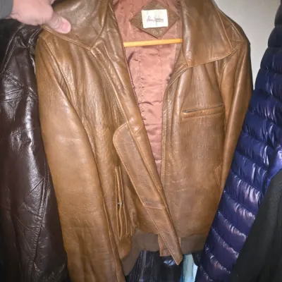 Sale Photo Thumbnail #65: Vintage tan leather bomber jacket featuring a wide collar, ribbed hem, and quilted inner lining.
