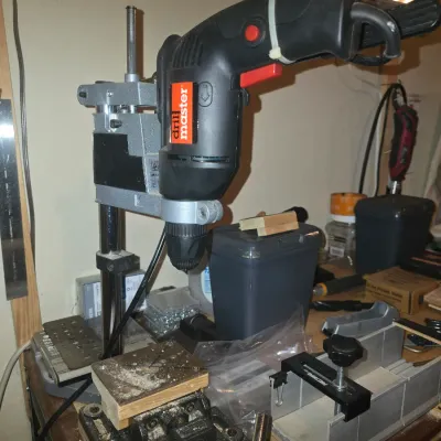 Sale Photo Thumbnail #70: Drill Master power drill mounted on a portable drill press stand, displayed on a workbench alongside a small vise and miter box.