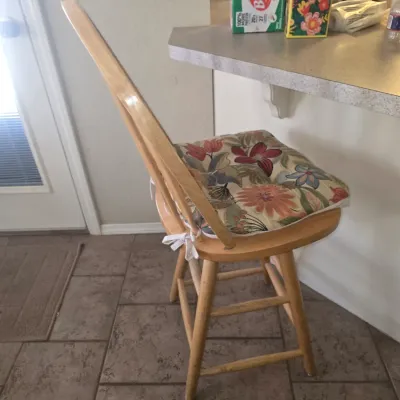 Sale Photo Thumbnail #82: Light oak swivel bar stool with a floral fabric tie-on seat cushion.