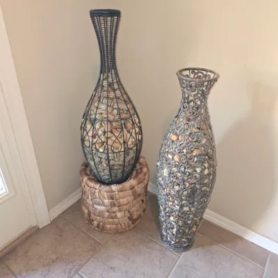 Sale Photo Thumbnail #61: Pair of tall metal openwork floor vases filled with wine corks, including one resting on a woven basket base.