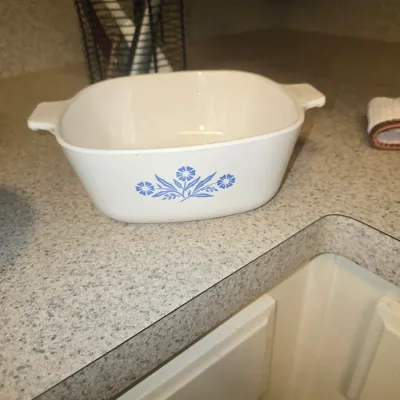 Sale Photo Thumbnail #113: Vintage CorningWare 'Cornflower Blue' square casserole dish resting on a kitchen countertop.