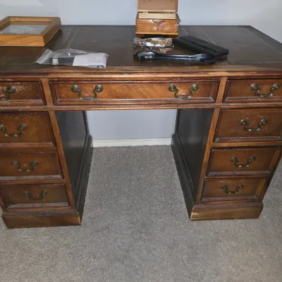 Sale Photo Thumbnail #27: Vintage executive pedestal desk in a dark wood finish with brass bail handles and a leather inlay top, showing light surface wear.