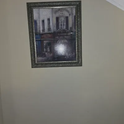 Sale Photo Thumbnail #31: Framed canvas print depicting a European street scene with storefronts, set in a beaded metallic frame.