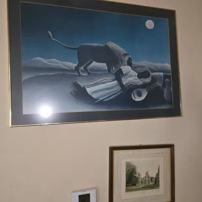 Sale Photo Thumbnail #54: Framed print reproduction of Henri Rousseau's 'The Sleeping Gypsy', alongside a smaller framed landscape art piece.