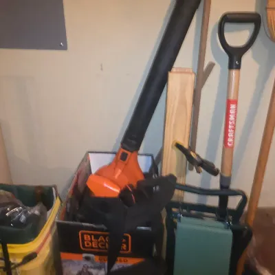 Sale Photo Thumbnail #74: Black & Decker electric leaf blower with original box, accompanied by a Craftsman shovel and a folding garden kneeler seat.