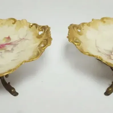 Sale Photo Thumbnail #27: 1027	OVAL CHINA DISHES W/FLORAL DECORATIONS & GILT EDGES ON METAL STAND W/DOLPHIN FEET, EACH APPROXIMATELY 11 IN X 9 IN X 4 IN HIGH																																																																																																																												