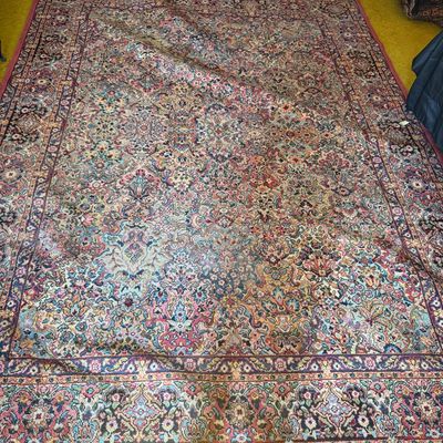 Sale Photo Thumbnail #66: Large Persian-style area rug featuring intricate floral motifs and a central medallion in shades of red, blue, cream, and green.