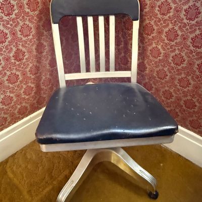 Sale Photo Thumbnail #9: Vintage industrial aluminum office desk chair with dark blue vinyl upholstery and a four-star wheeled base.