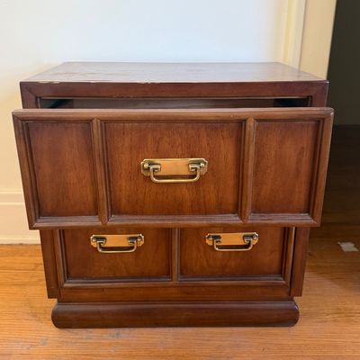 Sale Photo Thumbnail #5: Vintage campaign-style wooden nightstand with brass handles, showing light surface wear on the top and an open top drawer.