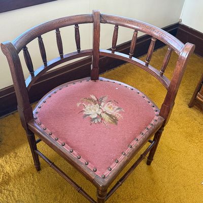 Sale Photo Thumbnail #48: Antique wooden corner chair featuring turned spindles, subtle floral carvings along the top rail, and a pink needlepoint floral upholstered seat with nailhead trim.
