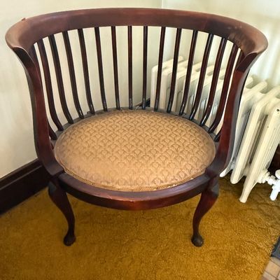 Sale Photo Thumbnail #61: Vintage dark wood barrel back accent chair with vertical spindles, cabriole legs, and a gold patterned upholstered seat cushion.