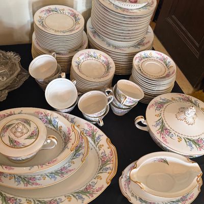 Sale Photo Thumbnail #31: Extensive porcelain china dinnerware set featuring delicate floral sprays, gold rim detailing, serving platters, tureen, teacups, and saucers.