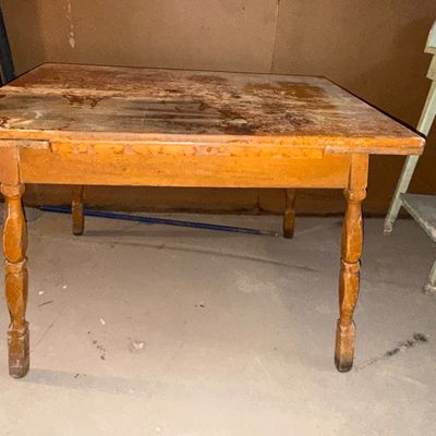 Sale Photo Thumbnail #10: Rustic wooden table with turned legs, showing heavy distress and finish wear on the top surface.