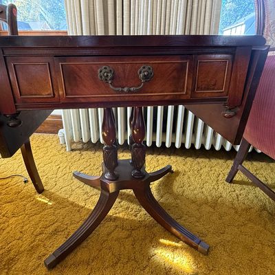 Sale Photo Thumbnail #50: Vintage mahogany drop-leaf Pembroke end table featuring a single drawer with ornate brass hardware and turned pedestal legs.
