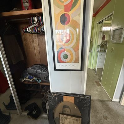 Framed Robert Delaunay "Rhythm - Spiral" abstract art print mounted on the wall alongside antique ornate portrait frames...