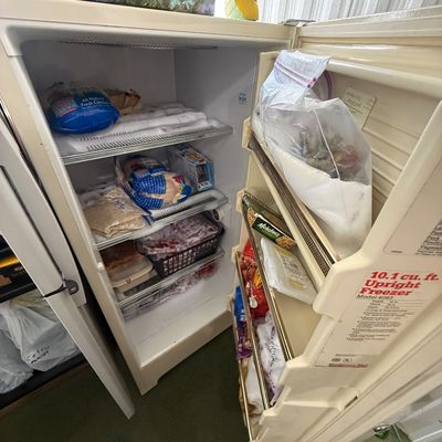 Vintage Montgomery Ward 10.1 cu. ft. upright freezer, featuring interior wire shelving and door storage racks.