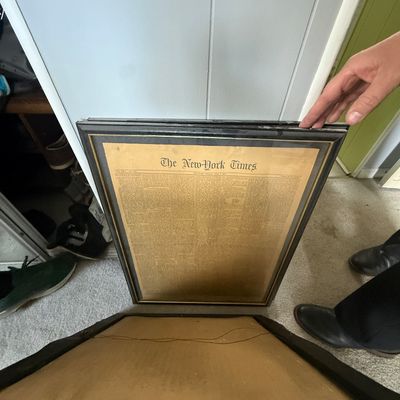 Framed historic copy of The New York Times front page in a dark wood frame with gold inlay trim.