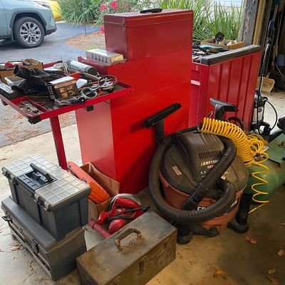 Sale Photo Thumbnail #108: Collection of garage tools and workshop equipment, including a red metal rolling tool chest, a Craftsman wet/dry shop vac, plastic portable toolboxes, and a vintage metal utility box.