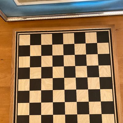 Sale Photo Thumbnail #182: Square wooden chessboard featuring alternating light birch and dark painted squares within a natural wood border frame.