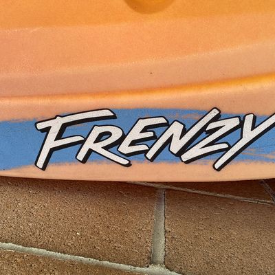 Sale Photo Thumbnail #139: Detail view of an Ocean Kayak Frenzy model sit-on-top kayak in a yellow and orange gradient.