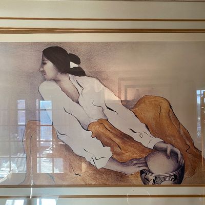 Sale Photo Thumbnail #84: Framed R.C. Gorman style lithograph depiction of a seated Indigenous woman with pottery, presented in a layered matte and neutral frame.