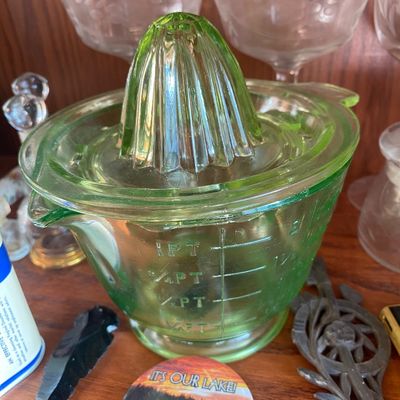 Sale Photo Thumbnail #186: Vintage green / Vaseline Depression glass citrus juicer with measuring marks, displayed alongside etched glassware and small collectibles.