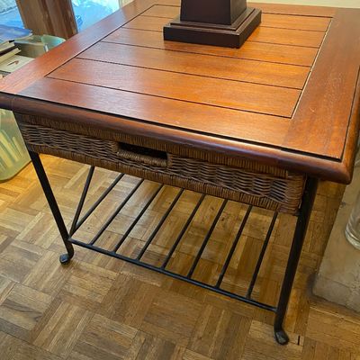 Sale Photo Thumbnail #30: Square wood side table featuring a slatted top, woven wicker apron, and a black wrought iron base with a slatted lower shelf.