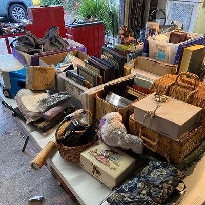 Sale Photo Thumbnail #107: Assorted household goods, picture frames, wicker baskets, and vintage trinket boxes arranged on folding tables in a garage.