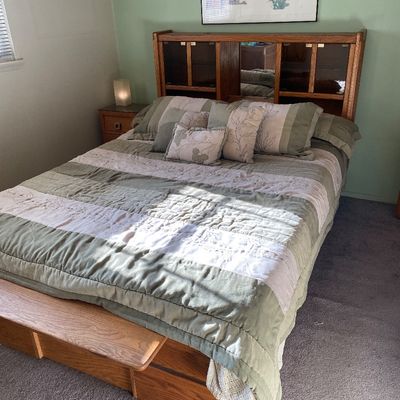 Sale Photo Thumbnail #82: Vintage oak platform bed frame featuring a bookcase headboard with mirrored and glass-front cabinets, paired with a matching wooden footboard bench.