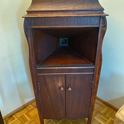 Sale Photo Thumbnail #26: Antique mahogany standing phonograph cabinet featuring carved details, an open internal speaker horn opening, and lower record storage doors.