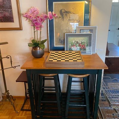 Sale Photo Thumbnail #22: Two-tone kitchen island table with two matching barstools, topped with a chessboard, faux potted orchid, and framed artwork.