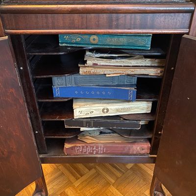 Sale Photo Thumbnail #28: Vintage dark wood corner phonograph record cabinet filled with early 20th-century 78 RPM record albums and loose shellac discs.