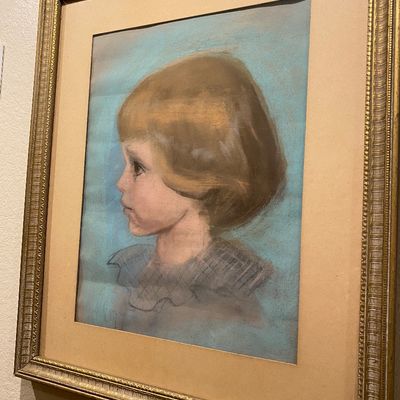Sale Photo Thumbnail #88: Framed pastel portrait of a young child in profile, rendered against a light blue background, housed in an ornate gold-tone wooden frame.