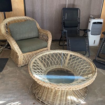 Sale Photo Thumbnail #5: Woven wicker armchair with green cushions paired with a matching glass-top wicker coffee table, displayed alongside a black folding zero-gravity chair.