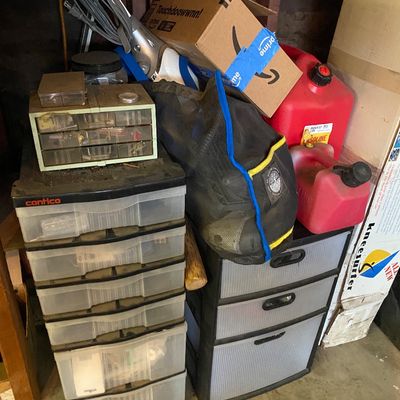 Sale Photo Thumbnail #110: Assorted workshop and garage items, including plastic drawer units, a small parts organizer, red gas cans, and a handheld vacuum.