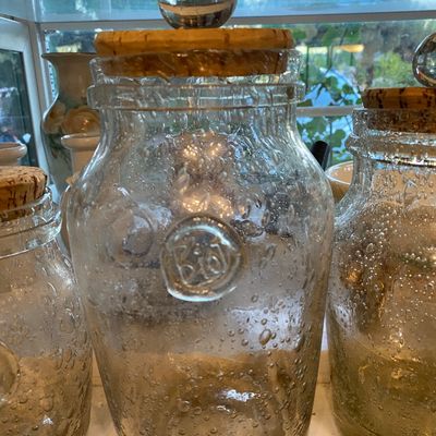 Sale Photo Thumbnail #96: Biot clear hand-blown glass storage jars featuring controlled bubble details and a cork stopper with a clear glass sphere handle.
