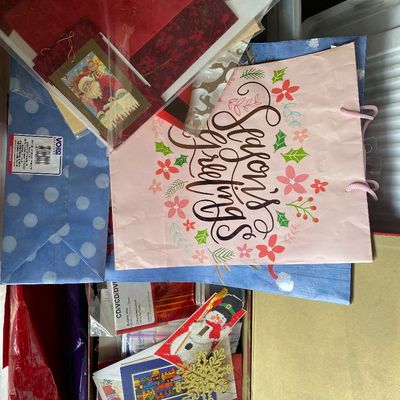 Sale Photo Thumbnail #119: Assortment of holiday gift wrapping supplies, including printed gift bags, greeting cards, tissue paper, and Christmas ornaments.