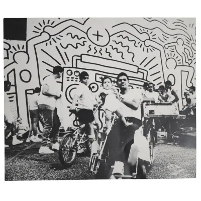 Sale Photo Thumbnail #177: KEITH HARING SIGNED 1986 CATALOGUE PHOTO WITH DRAWN EMBELLISHMENTS