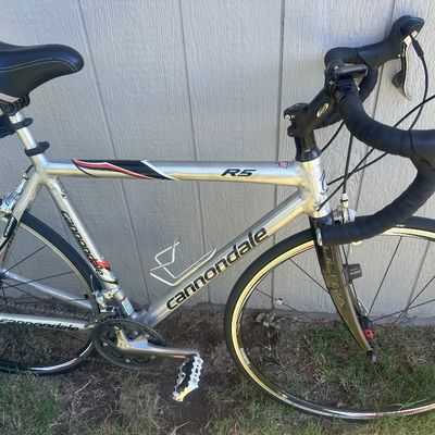 Sale Photo Thumbnail #10: Cannondale R5 road bike in brushed aluminum finish, featuring an Ultra carbon fork, Shimano components, drop handlebars, and a water bottle cage.