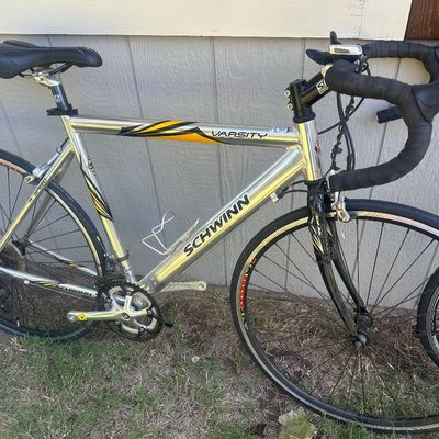 Sale Photo Thumbnail #11: Schwinn Varsity 14-speed road bike featuring a brushed aluminum frame, drop handlebars, and yellow and black graphics.