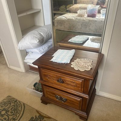 Sale Photo Thumbnail #60: Traditional dark wood two-drawer nightstand with carved detailing and antique-style brass hardware.
