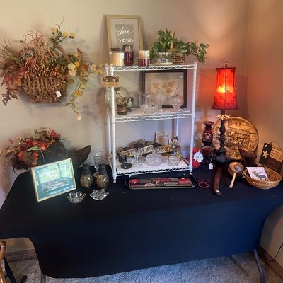 Sale Photo Thumbnail #24: Tabletop display featuring a white wire baker's rack, candles, glassware, framed artwork, and autumn-themed floral decorations.