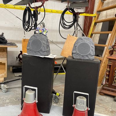 Sale Photo Thumbnail #57: Collection of audio and lighting equipment including two red vintage horn speakers, black tower speakers topped with rock-style speakers, and large studio stage lights.